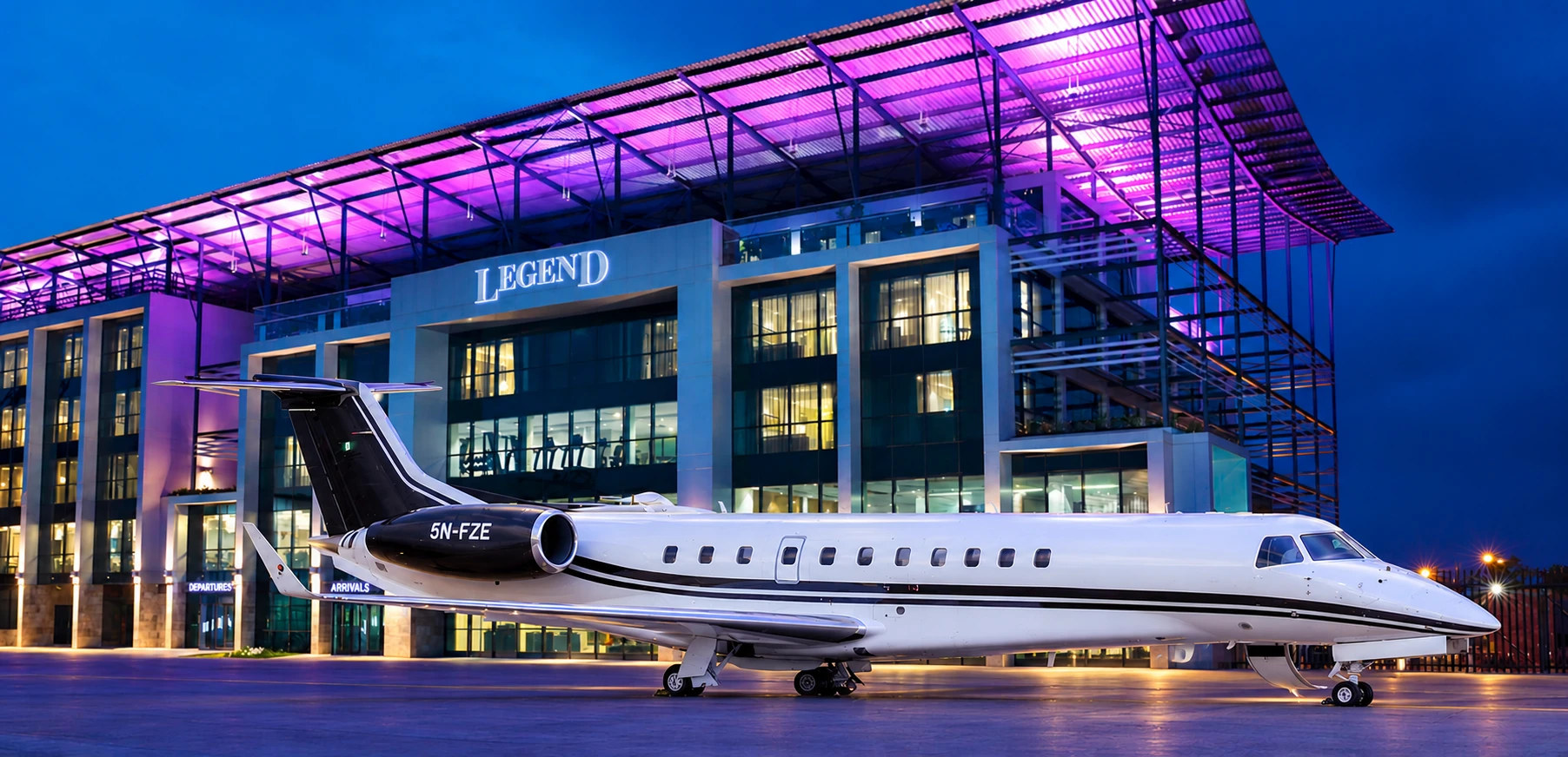 Executive Jets Embraer Legacy 600, registration 5N-FZE, on the apron before the illuminated Legend terminal at Murtala Muhammed International Airport, Lagos, at dusk